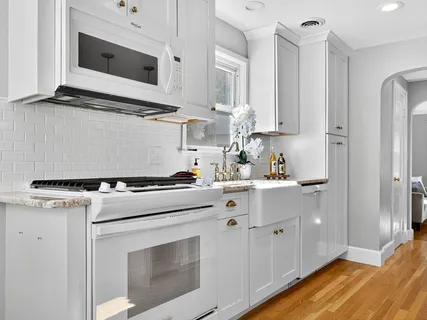a kitchen with stainless steel appliances white cabinets and a stove
