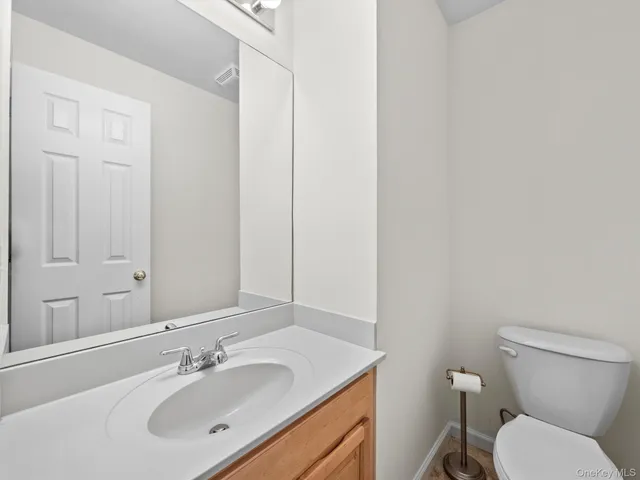 a bathroom with a toilet sink vanity and mirror