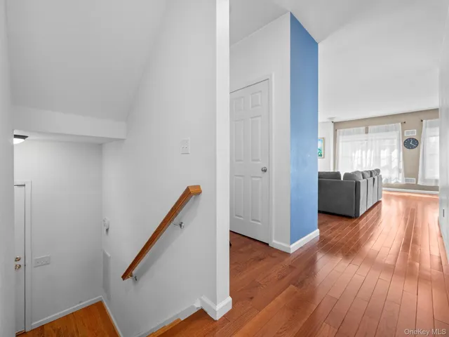 a view of a hallway with wooden floor and staircase