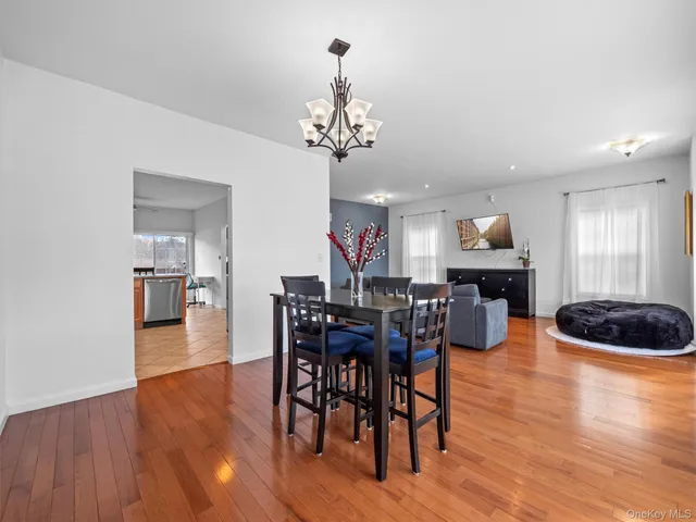 a view of a dining room with furniture a chandelier and wooden floor
