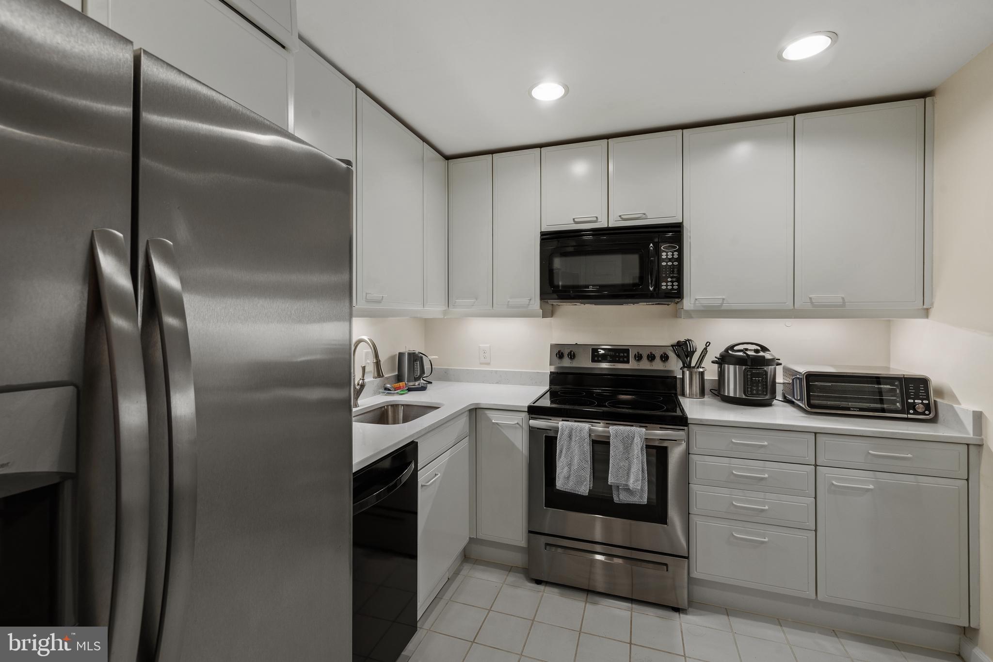 3801 Canterbury Road, Unit 708 Baltimore, MD 21218 - Photo 16 of 22 a kitchen with stainless steel appliances granite countertop a stove and a refrigerator