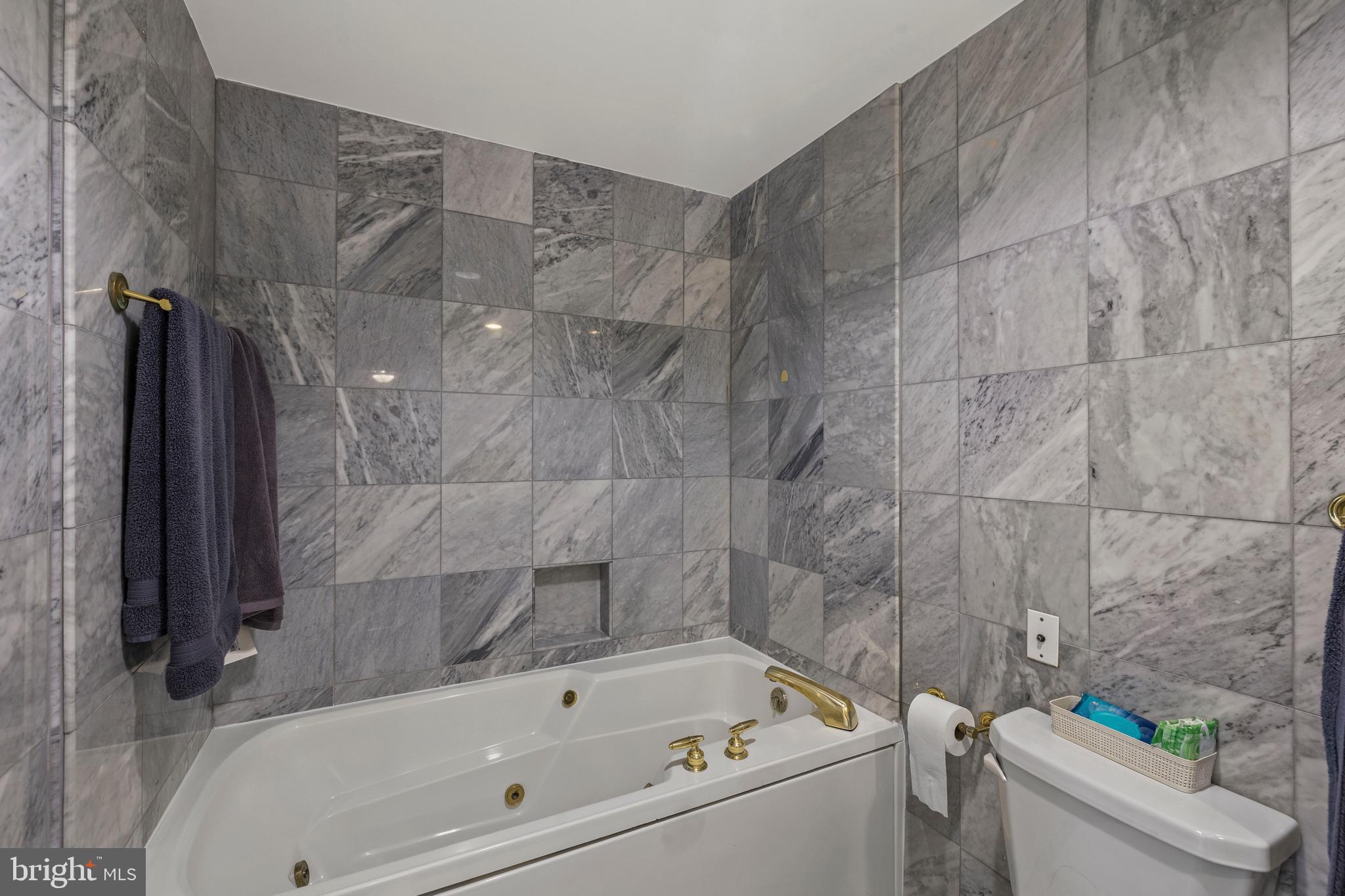 3801 Canterbury Road, Unit 708 Baltimore, MD 21218 - Photo 19 of 22 a bathroom with a bathtub and a toilet