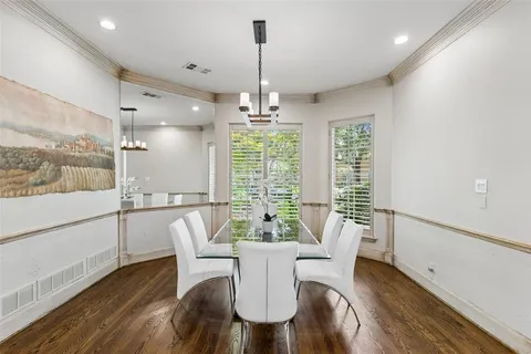 a dining room with furniture a chandelier and wooden floor