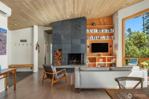 a living room with furniture a flat screen tv and a fireplace