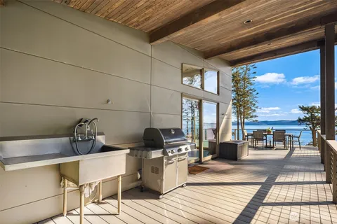 a view of a patio with dining table and chairs with wooden floor and fence