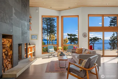 a living room with fireplace furniture and a large window