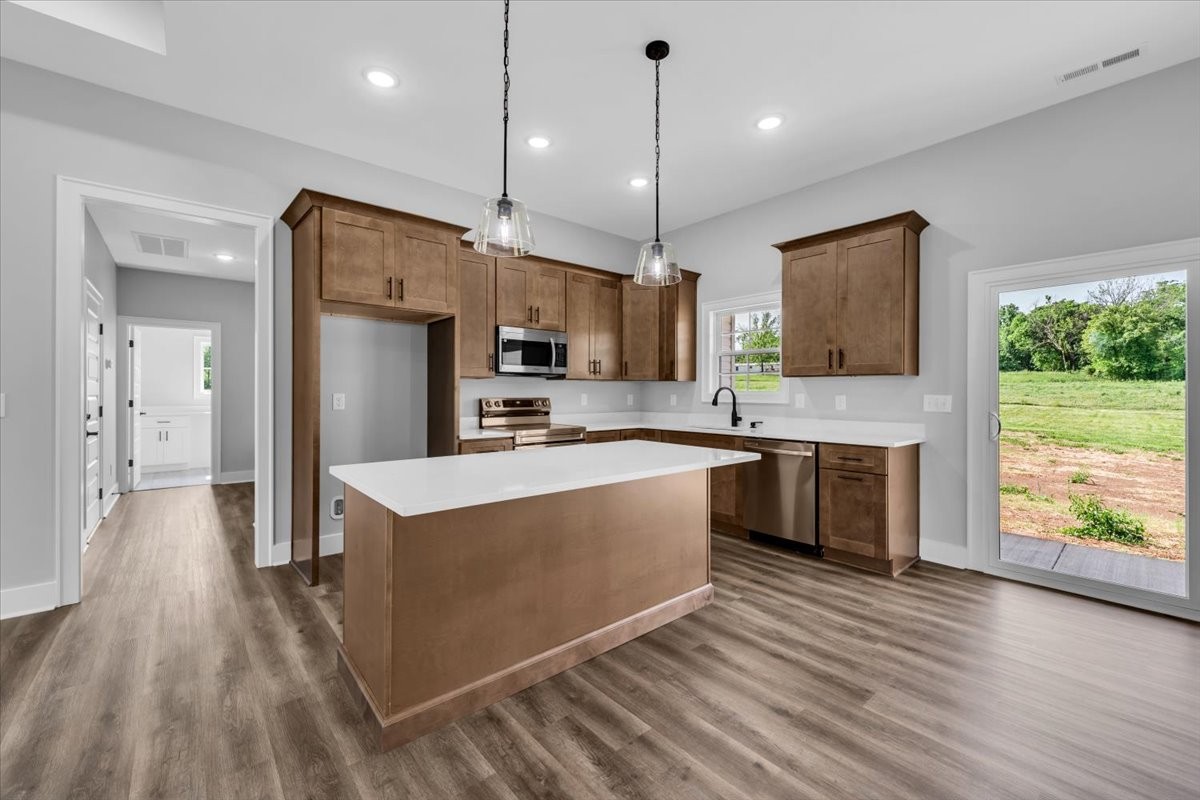 749 Edd Ramsey Road McMinnville, TN 37110 - Photo 12 of 40 a large kitchen with stainless steel appliances granite countertop a stove a sink dishwasher a refrigerator and a wooden floor