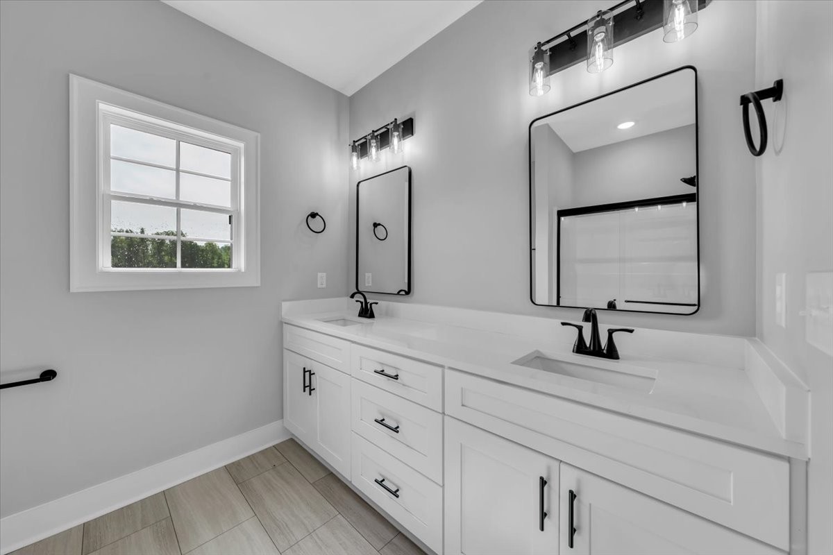 749 Edd Ramsey Road McMinnville, TN 37110 - Photo 32 of 40 a bathroom with double vanity sink a mirror and a window