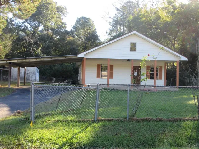 a view of a yard in front of a house with a large tree