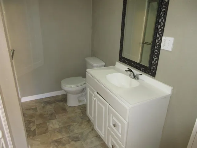 a bathroom with a sink a toilet and mirror