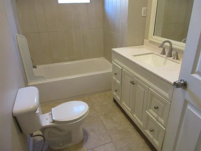 a bathroom with a sink mirror vanity and toilet