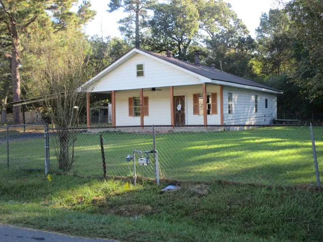 a front view of a house with a yard and trees
