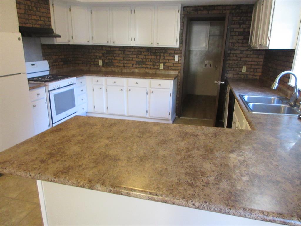 1021 Scarpengo Road Shreveport, LA 71107 - Photo 6 of 22 a kitchen with granite countertop a sink a stove and granite counter tops