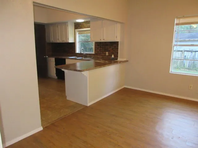 a kitchen with stainless steel appliances a sink a stove a microwave a refrigerator a window