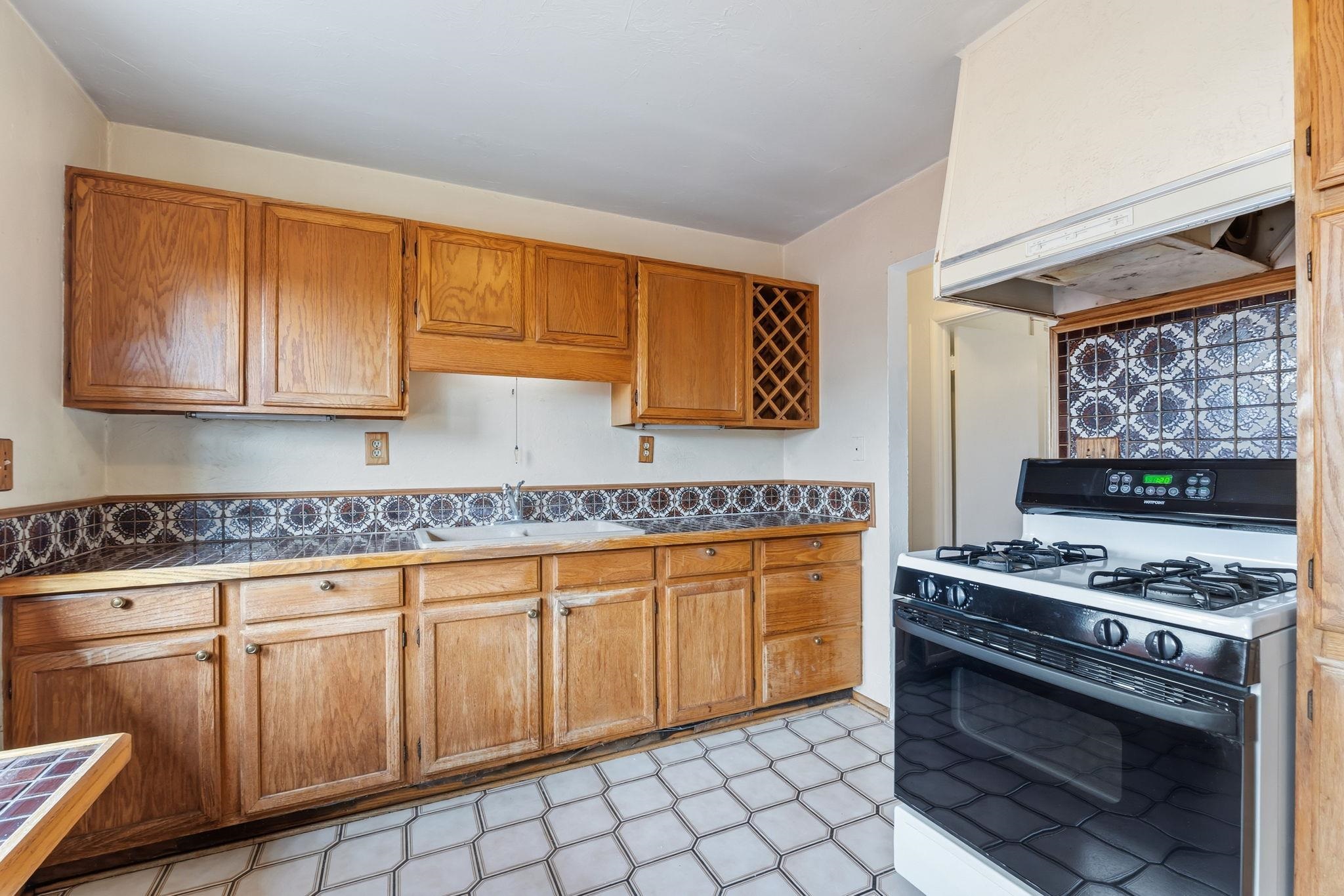 1609 Darwin Street Seaside, CA 93955 - Photo 12 of 26 Kitchen with gas stove, light floors, wood finish cabinets, and tile countertops