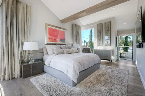 a bedroom with a large bed and a chandelier