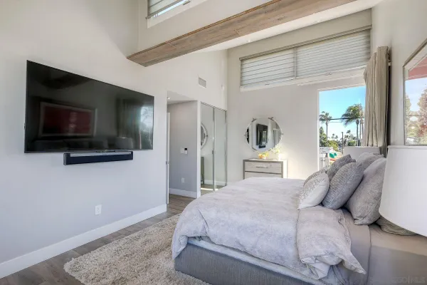 a bedroom with a bed and a flat screen tv
