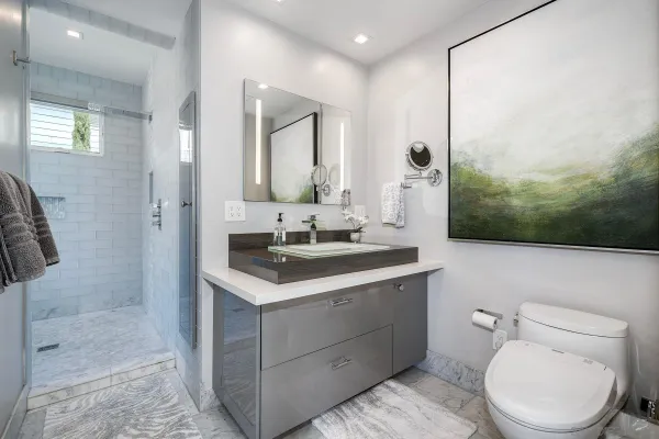 a bathroom with a sink a toilet and shower