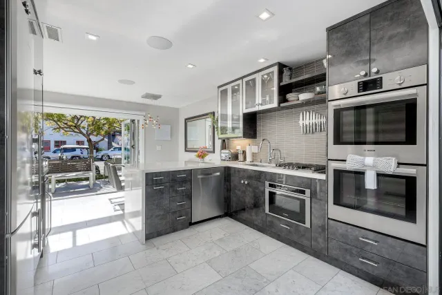 a large kitchen with stainless steel appliances granite countertop a stove and a sink
