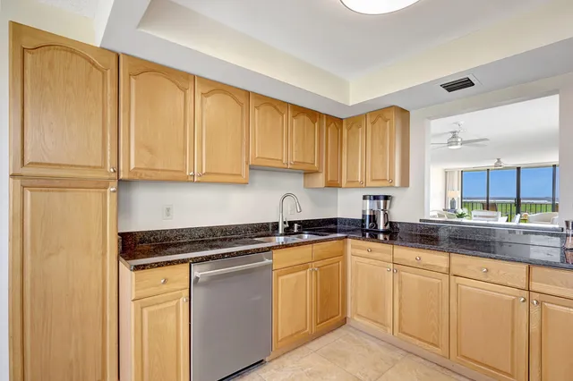 a kitchen with a sink a refrigerator and cabinets