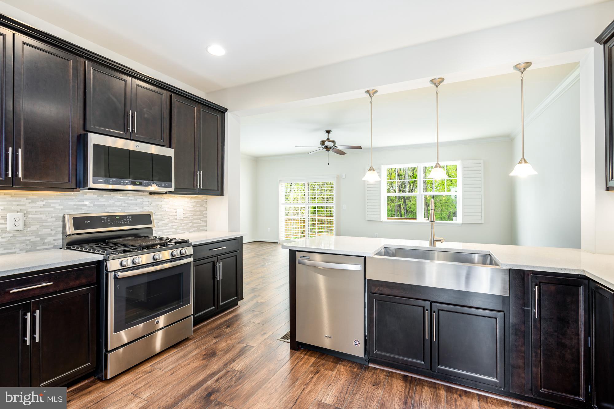 112 Prickly Pear Place Stephenson, VA 22656 - Photo 12 of 31 a kitchen with stainless steel appliances wooden cabinets and a stove top oven