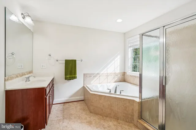 a bathroom with a tub sink and mirror