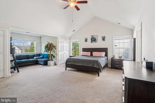 a bedroom with a bed a couch and a chandelier