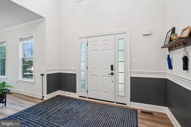 a view of a livingroom with wooden floor and a kitchen space