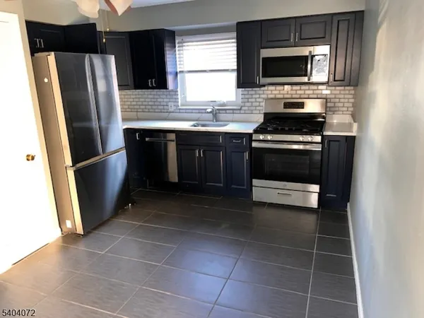 a kitchen with stainless steel appliances a stove a microwave and a refrigerator