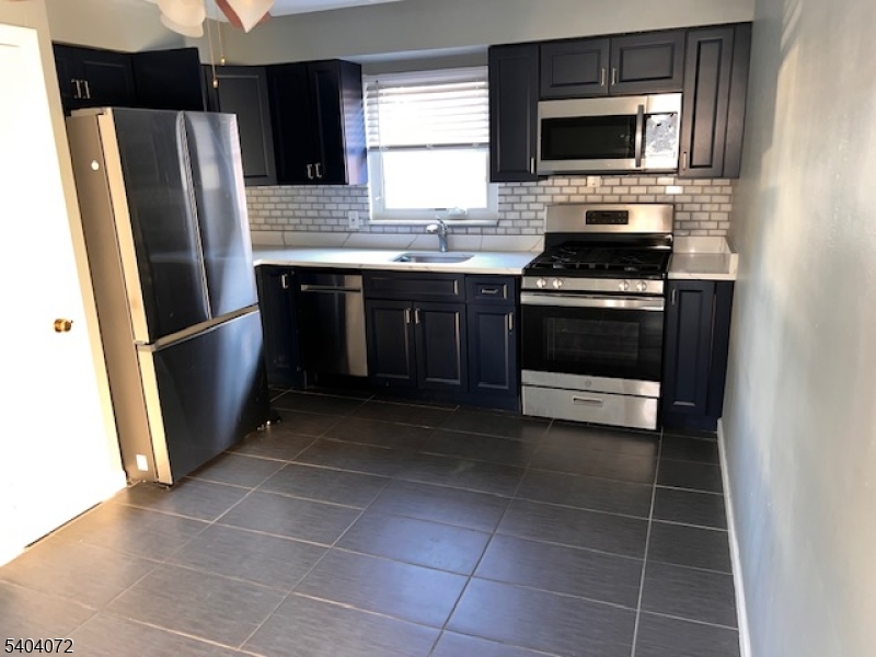 a kitchen with stainless steel appliances a stove a microwave and a refrigerator