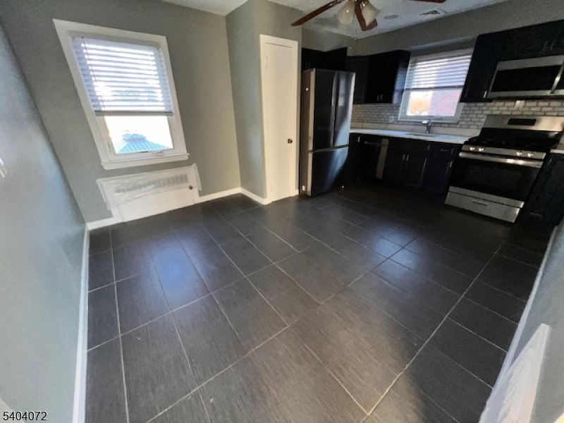 10 Federal Street, Unit 2 Belleville, NJ 07109 - Photo 2 of 10 a kitchen with granite countertop a stove a sink and a microwave