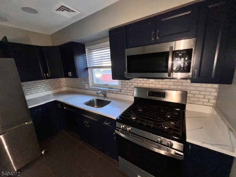 10 Federal Street, Unit 2 Belleville, NJ 07109 - Photo 3 of 10 a kitchen with sink a microwave a stove and cabinets