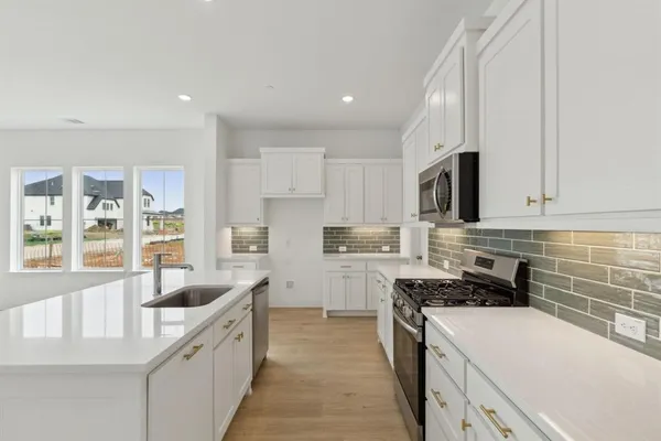 a kitchen that has a lot of cabinets in it and appliances