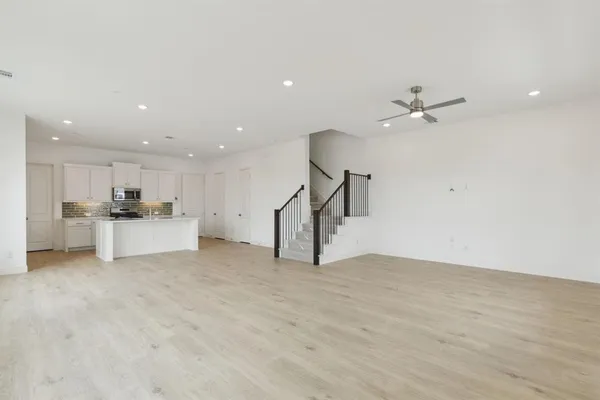 a view of kitchen with refrigerator and white cabinets