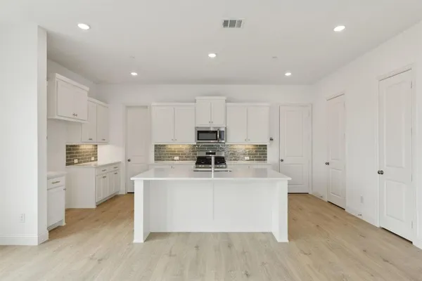 a kitchen with a stove a sink and a refrigerator