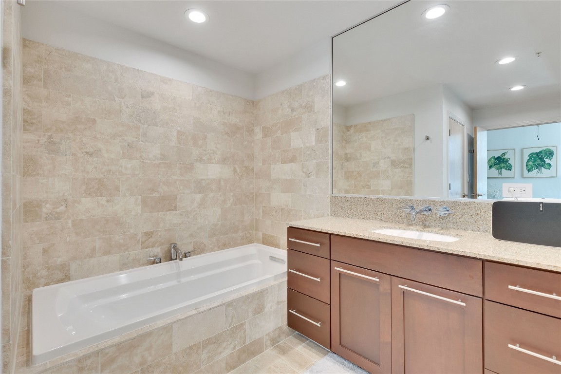 1600 Barton Springs Road, Unit 2403 Austin, TX 78704 - Photo 21 of 40 a bathroom with a granite countertop bathtub sink vanity and mirror
