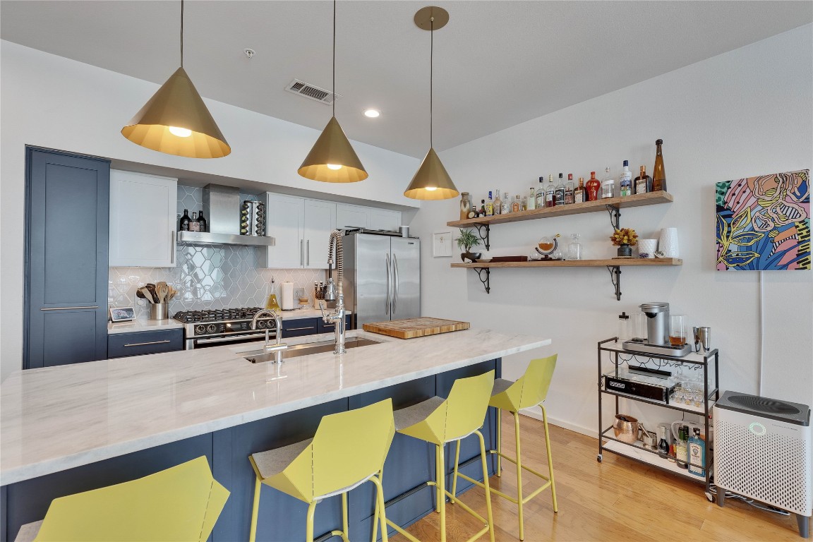 1600 Barton Springs Road, Unit 2403 Austin, TX 78704 - Photo 5 of 40 a kitchen with stainless steel appliances granite countertop a dining table chairs sink and stove top oven