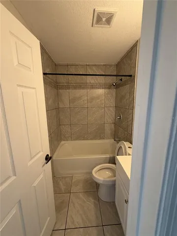 a bathroom with a granite countertop bathtub toilet and sink