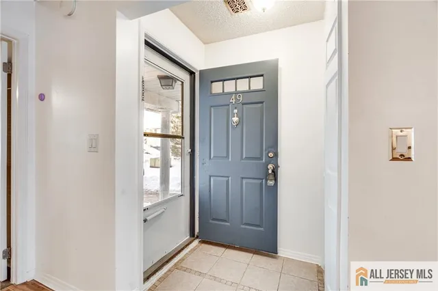 a view of empty room with wooden floor and a fireplace