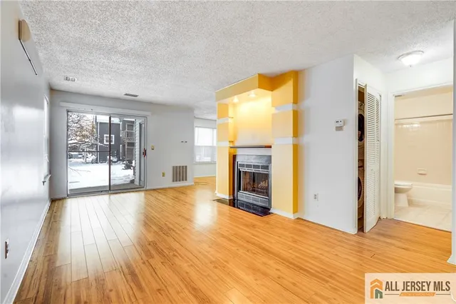 a view of a kitchen with wooden floor and a refrigerator