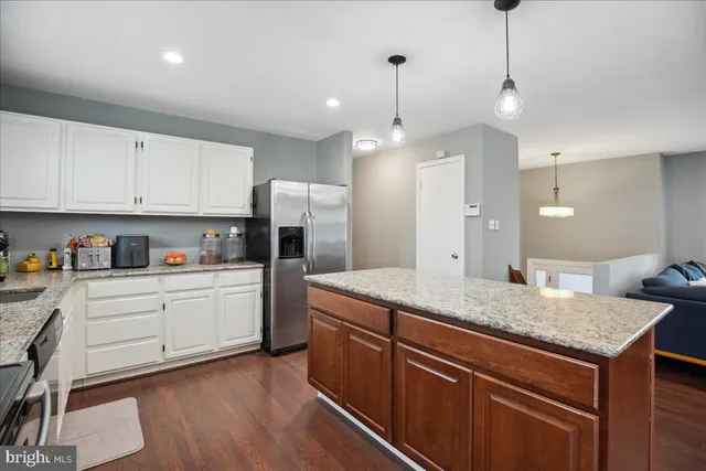 a kitchen with granite countertop white cabinets stainless steel appliances and a sink
