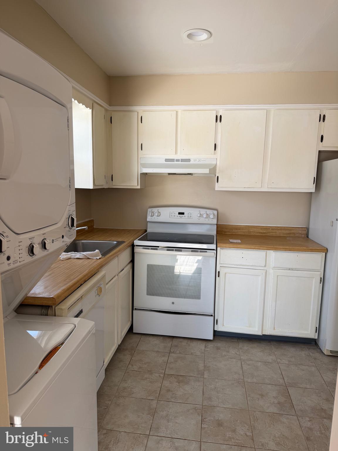 a kitchen with granite countertop white cabinets and white appliances