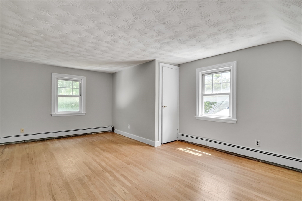 17 Beech Circle Andover, MA 01810 - Photo 27 of 36 an empty room with wooden floor and windows