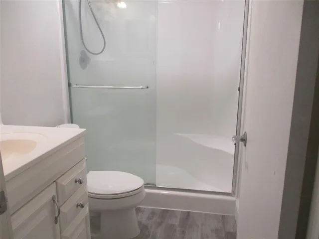 a bathroom with a shower a toilet and a sink