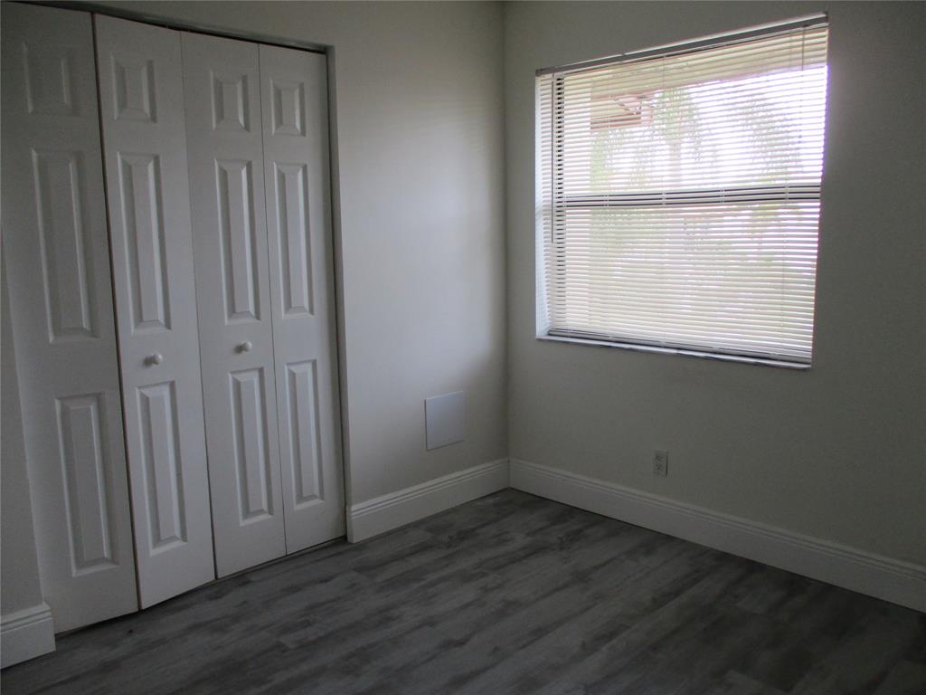 22040 Palms Way, Unit 205 Boca Raton, FL 33433 - Photo 12 of 19 an empty room with wooden floor and windows