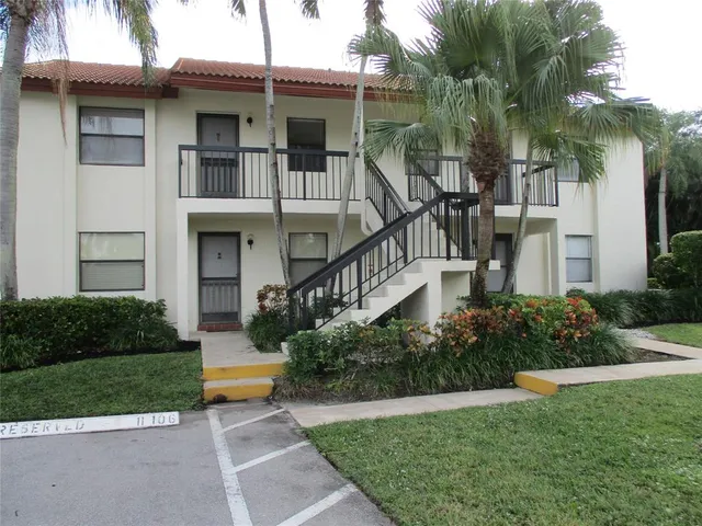a front view of a house with a yard and potted plants