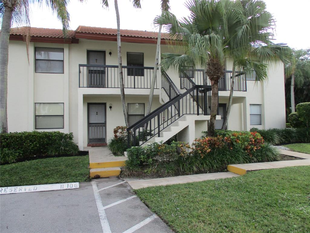 22040 Palms Way, Unit 205 Boca Raton, FL 33433 - Photo 2 of 19 a front view of a house with a yard and potted plants