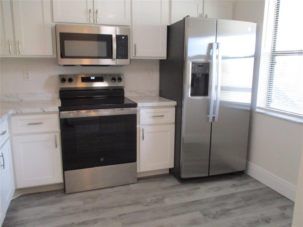 22040 Palms Way, Unit 205 Boca Raton, FL 33433 - Photo 6 of 19 a kitchen with stainless steel appliances a refrigerator stove and microwave