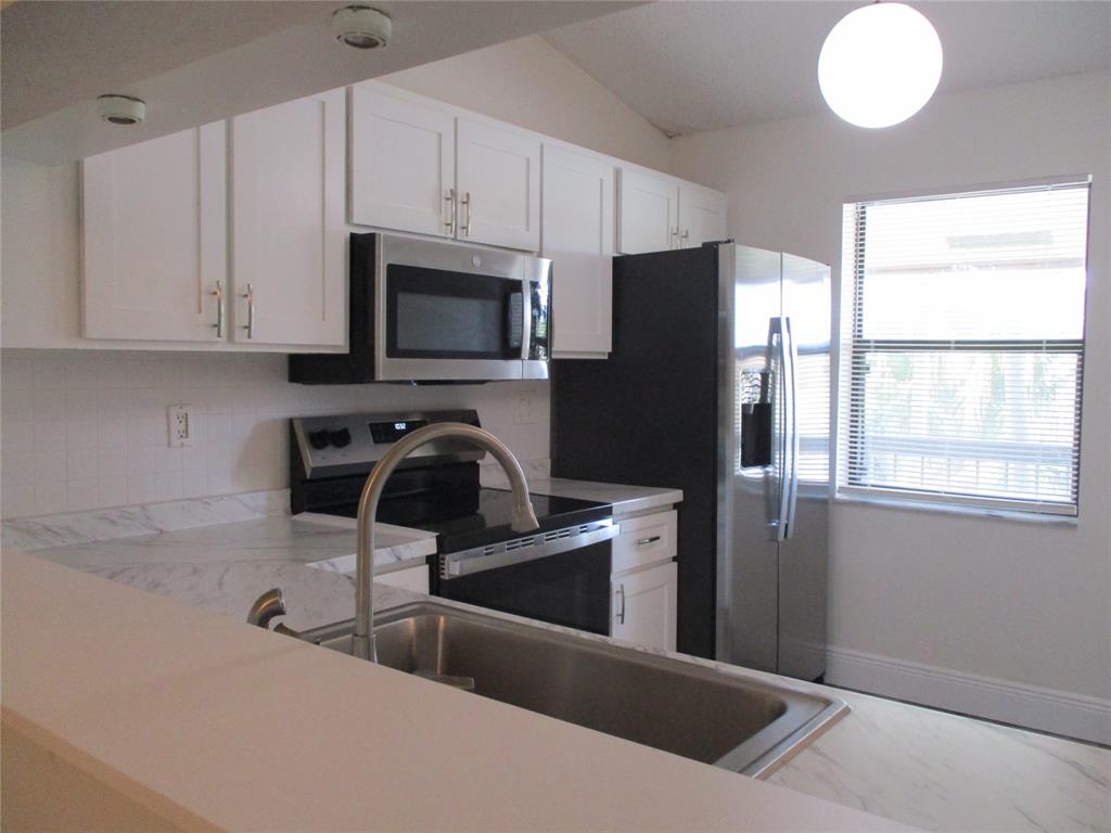 22040 Palms Way, Unit 205 Boca Raton, FL 33433 - Photo 8 of 19 a kitchen with stainless steel appliances granite countertop a refrigerator and a sink