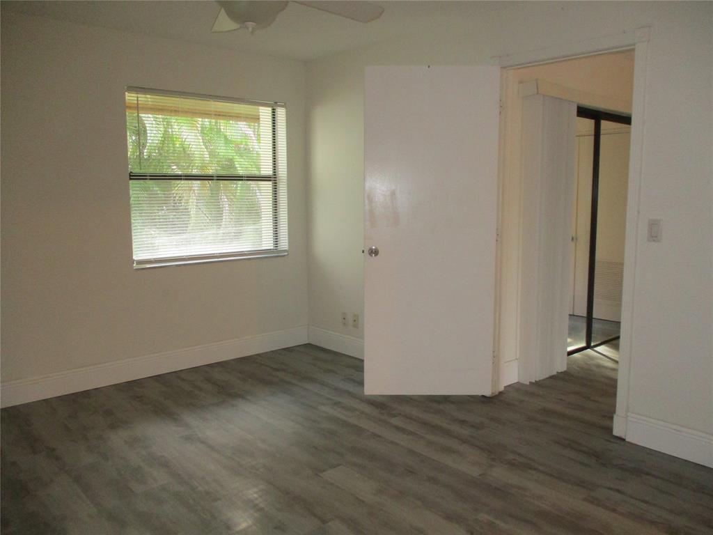 22040 Palms Way, Unit 205 Boca Raton, FL 33433 - Photo 10 of 19 an empty room with wooden floor and windows